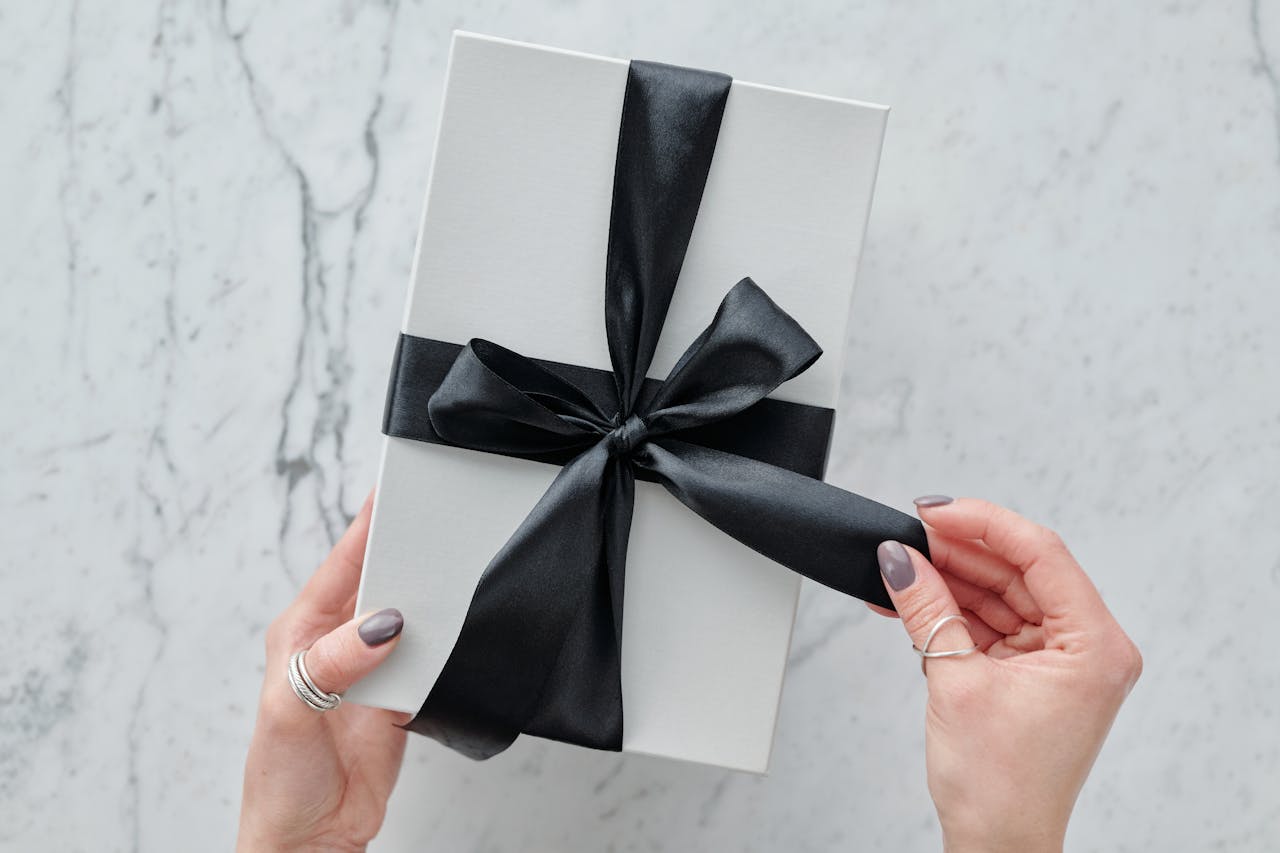 A sleek white present tied with a black satin ribbon, providing a touch of luxury. Ideal for gift themes.